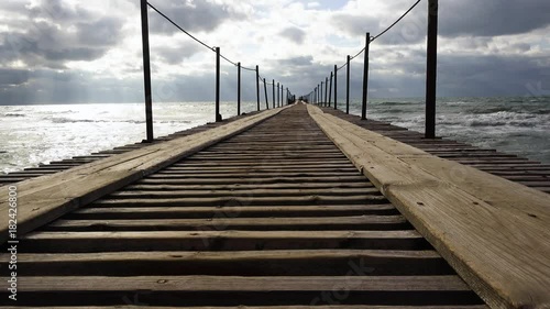 Beautiful old wooden mooring leaving in the stormy sea and in the sky of the cloud