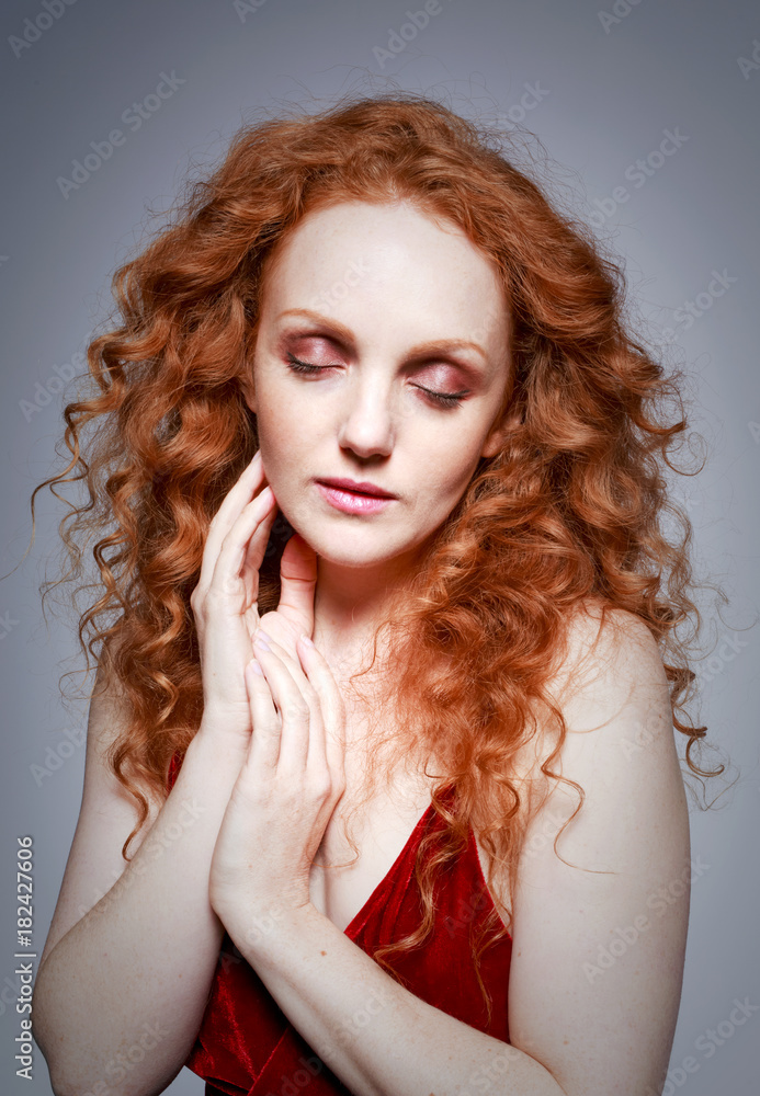 Fototapeta premium portrait of beautiful lady with long curly red hair