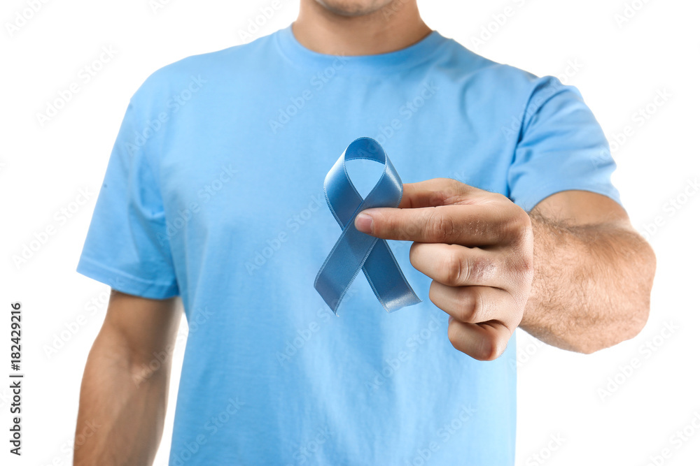 Young man holding blue ribbon on white background. Cancer concept Young man holding blue ribbon on white background. Cancer concept