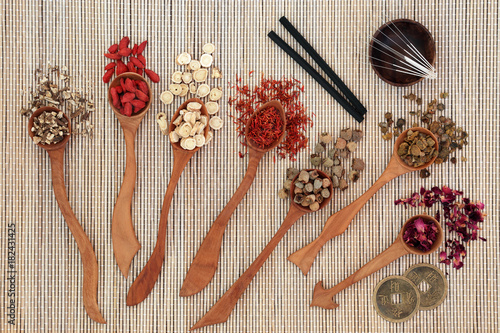 Fototapeta Naklejka Na Ścianę i Meble -  Chinese herbal medicine with herbs in wooden spoons, acupuncture needles and moxa sticks used in moxibustion therapy with feng shui coins on bamboo background. Top view.