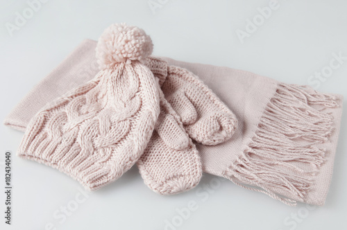 Pale pink gloves, scarf and woolen hat woman winter set on white background