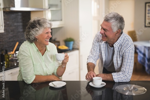 Senior couple looking at each other while having coffee at home