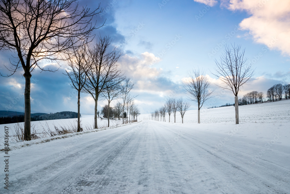 Empty snow covered road in winter with trees Empty snow covered road in winter with trees