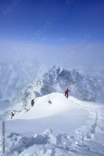 Female skier ascending on snowface to Piz Zuort, Switzerland 