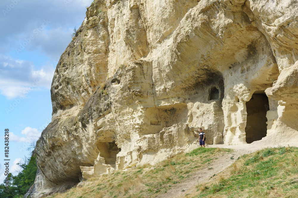 A tourist stands on the natural boundary of Mariam-Dere (Maria's Gorge) near Bakhchisarai. Cave city Chufut-Kale