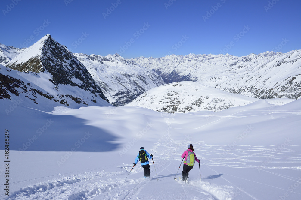Two female back-country skiers downhill skiing from Eiskoegele, Obergurgl, Oetztal Alps, Tyrol, Austria Two female back-country skiers downhill skiing from Eiskoegele, Obergurgl, Oetztal Alps, Tyrol, Austria