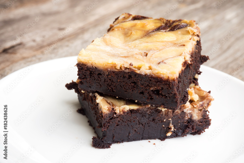 Cheese brownies on white plate. Homemade dessert for chocolate lover. Served on wooden table. Cheese brownies on white plate. Homemade dessert for chocolate lover. Served on wooden table.