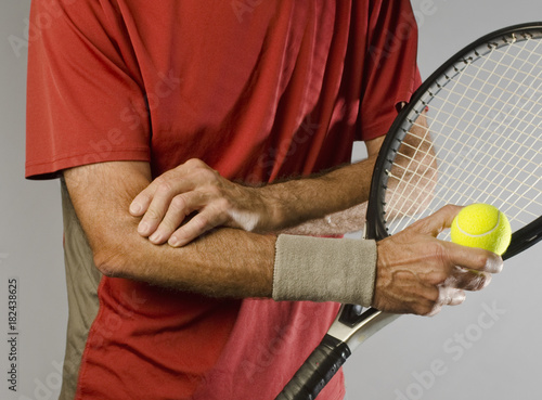 Canvas Print male tennis player massaging painful elbow holding racket
