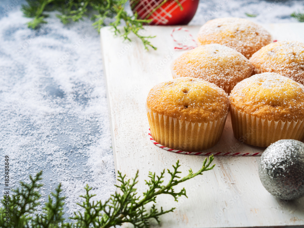 Christmas baking concept - muffins with icing sugar and festive winter decorations