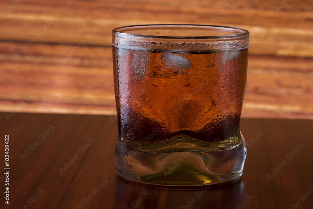 Glass of wiskey and ice on wooden background Glass of wiskey and ice on wooden background