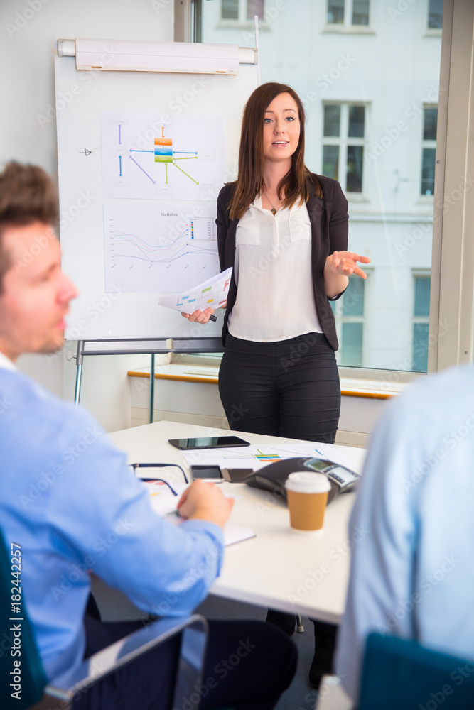Fototapeta premium Female Professional Giving Presentation To Colleagues