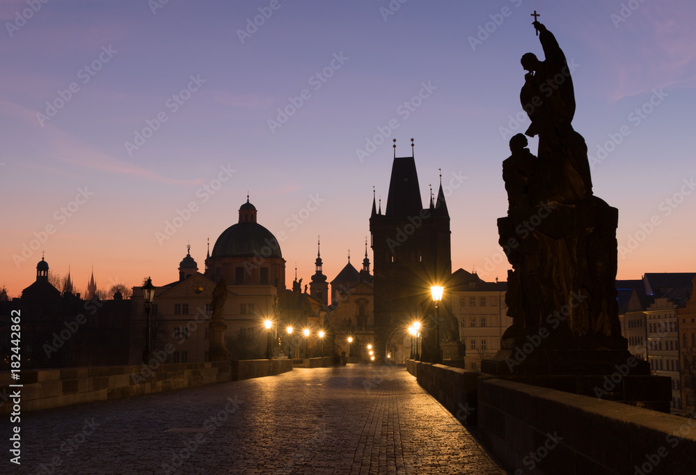 Famous Charles bridge before sunrise - silhouettes of towers and statues in Prague, Czech Republic