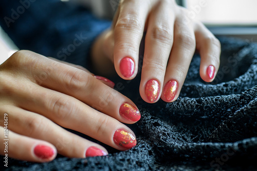 Foto Woman with beautiful manicured red fingernails gracefully crossing her hands to