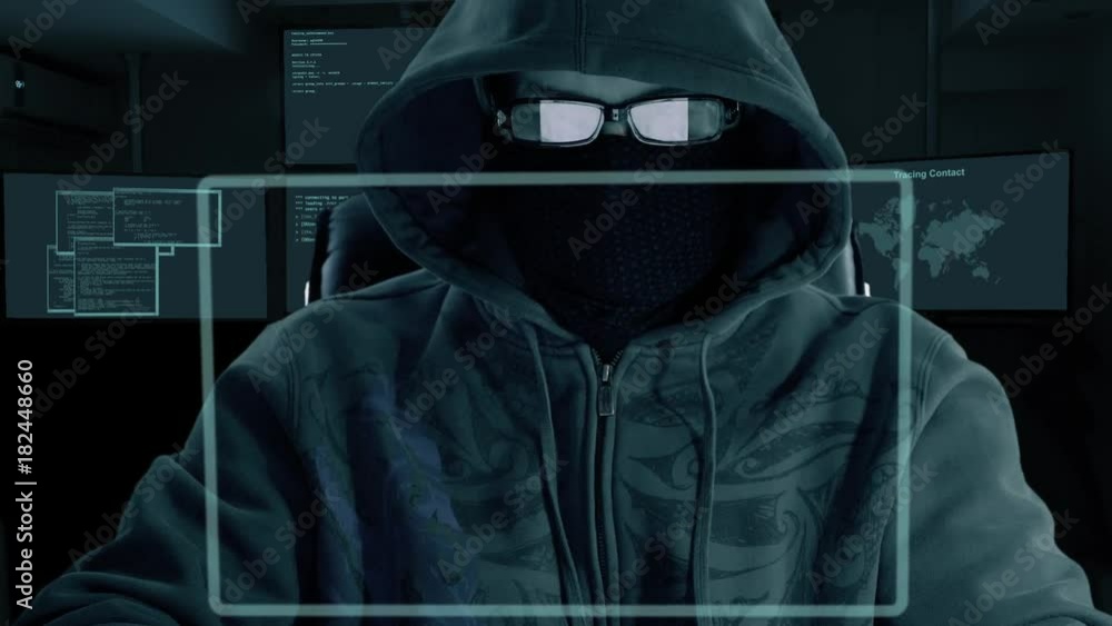 Man in hood glasses and mask of balaclava sits at the computer laptop and downloads secret data. A hacker at night hack websites. Virtual screen front view.