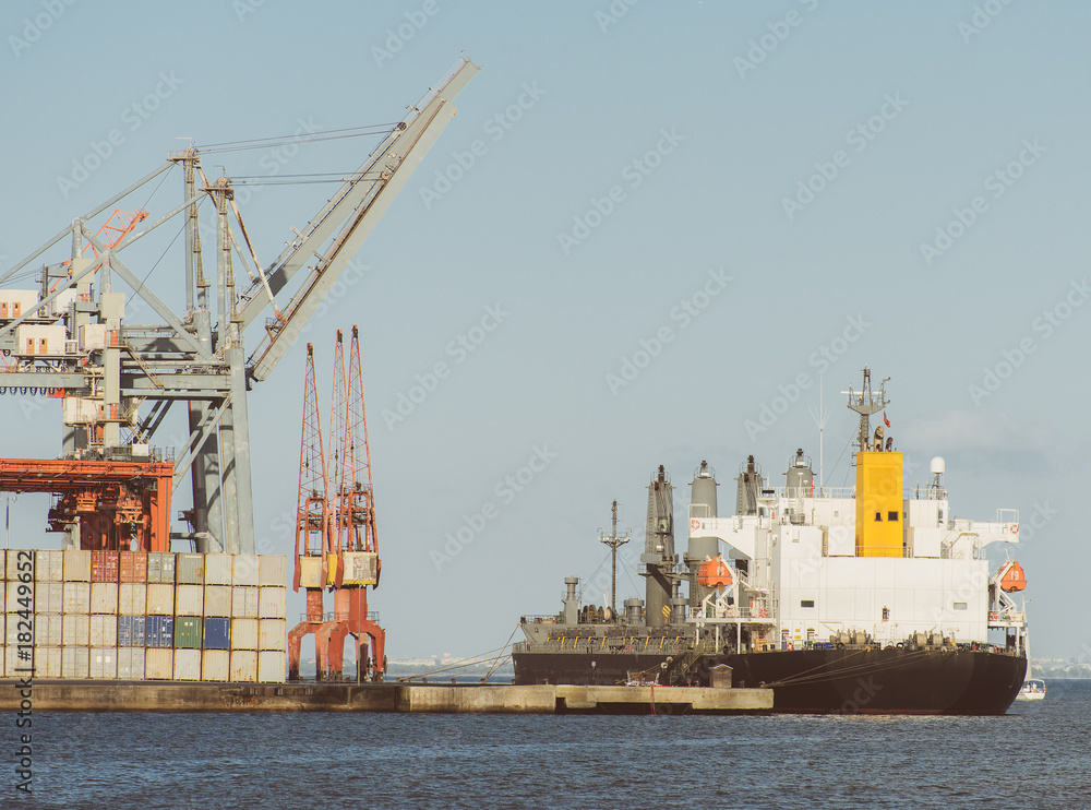 Industrial sea port with containers and cranes and ship.