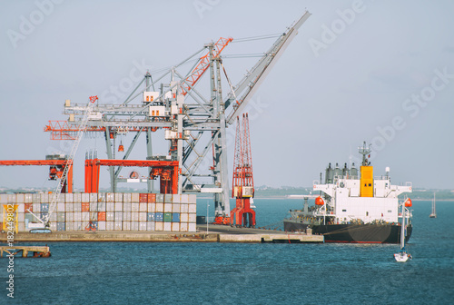 Industrial sea port with containers and cranes and ship.