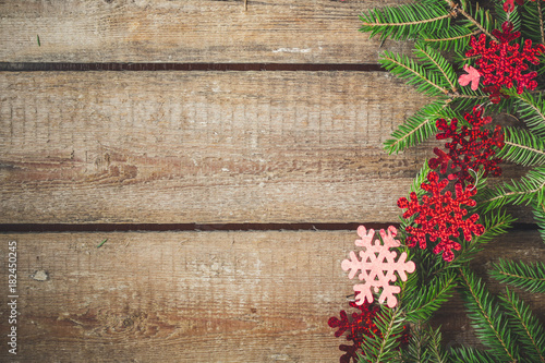 fir christmas tree and garland on a wooden texture (background)