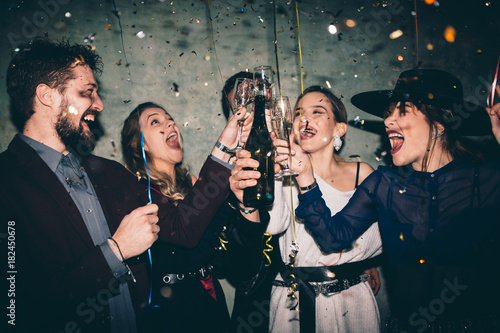 Photo Group of happy friends drinking champagne and celebrating New Year
