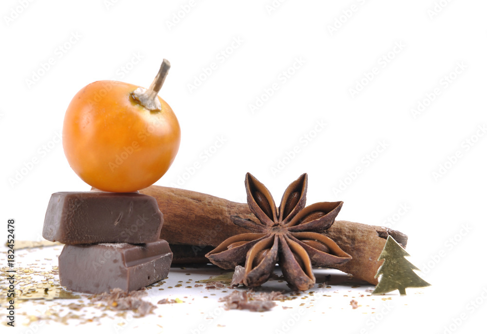 fruit of physalis on piece of chocolate with anise, cinnamon and cookies on white background