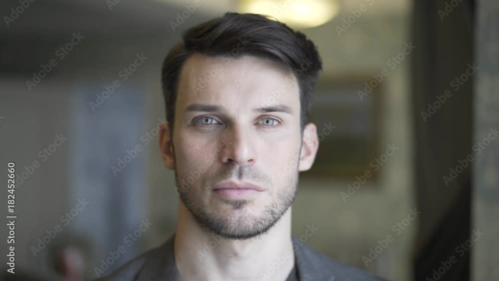 Headshot of a handsome young man with a beard turning his head to look at the viewer. Handheld real time establishing shot Headshot of a handsome young man with a beard turning his head to look at the viewer. Handheld real time establishing shot