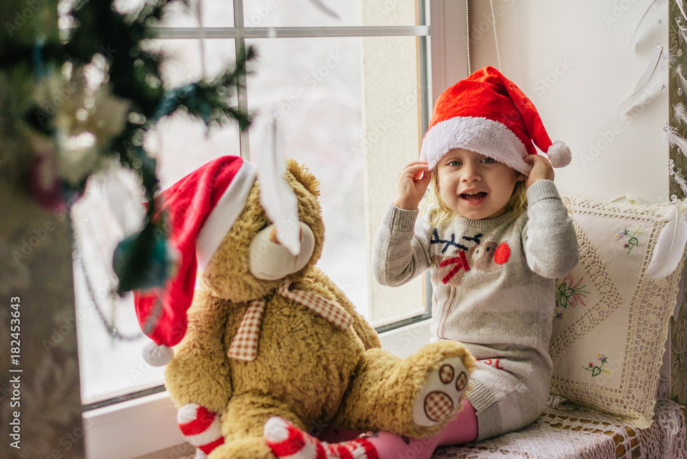 happy child girl sitting back in the winter window Christmas happy child girl sitting back in the winter window Christmas