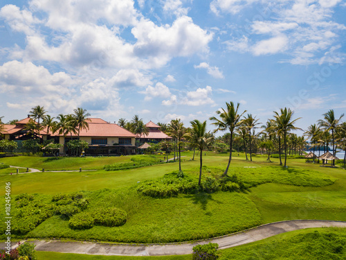 Golf club with green hills and many palm trees near Tanah lot temple  Bali island  Indonesia.