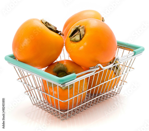 Persimmon Kaki in a shopping basket isolated on white background. photo