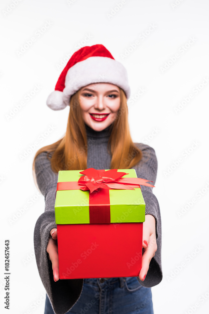 Happy excited young woman in santa claus hat with gift box over white background Happy excited young woman in santa claus hat with gift box over white background