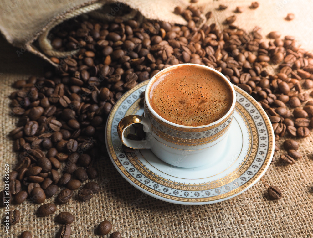 Fototapeta premium Espresso coffee Cup with beans on a burlap background. 