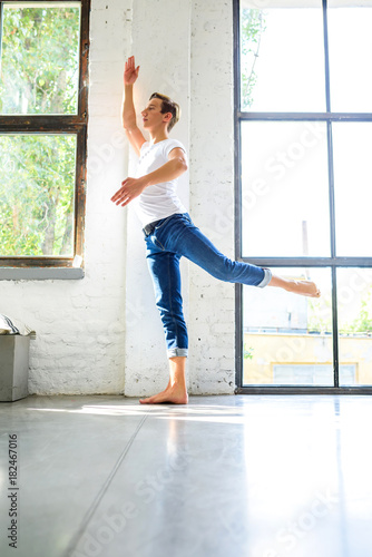 Fototapeta Naklejka Na Ścianę i Meble -  A handsome young male Ballet dancer practicing in a Loft style A