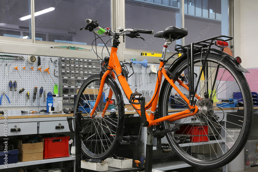 bicycle repair workshop with one orange bike