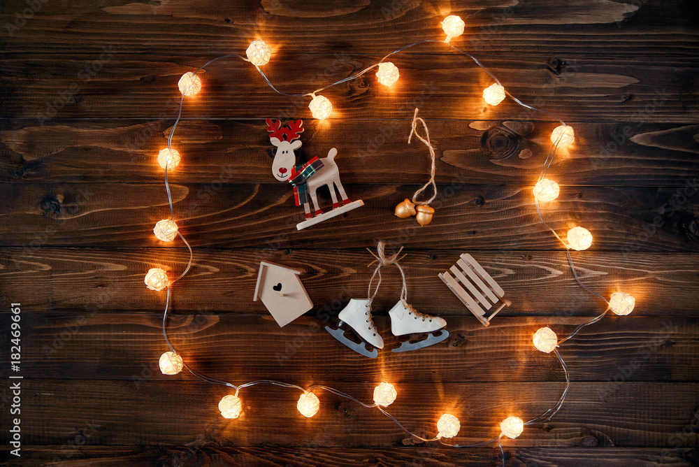 Christmas lights and handmade festive decorations on a wooden background.