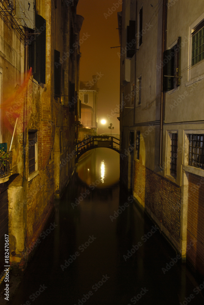 Canal in Venice (Italy) by night. bridge reflection in canal water. Long exposure