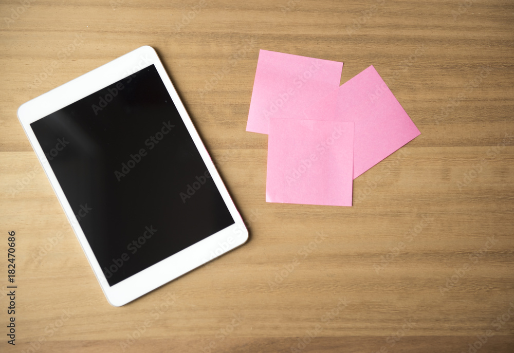 Background image of a tablet device with colourful note paper, taken with copy space Background image of a tablet device with colourful note paper, taken with copy space