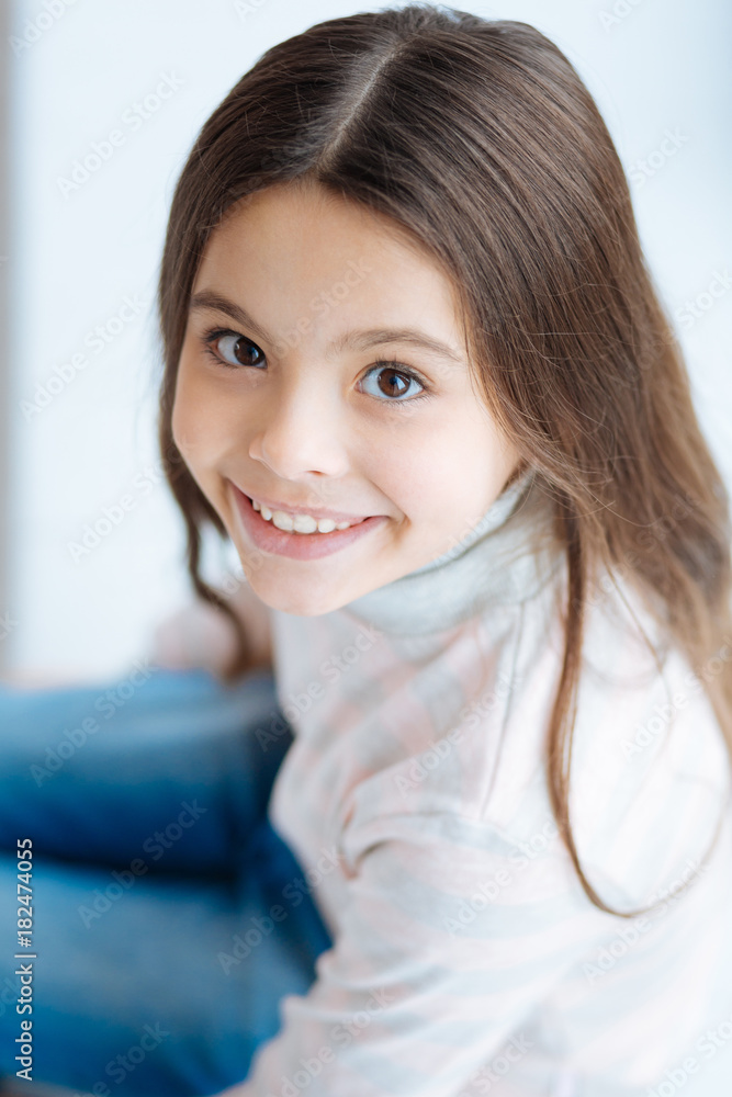 Irresistible smile. Top view of sweet cute little girl who sitting and gazing at the camera while smiling happily Irresistible smile. Top view of sweet cute little girl who sitting and gazing at the camera while smiling happily