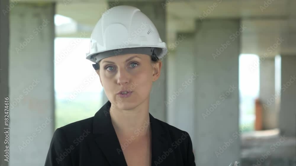 Construction female worker on building site talking to camera Construction female worker on building site talking to camera