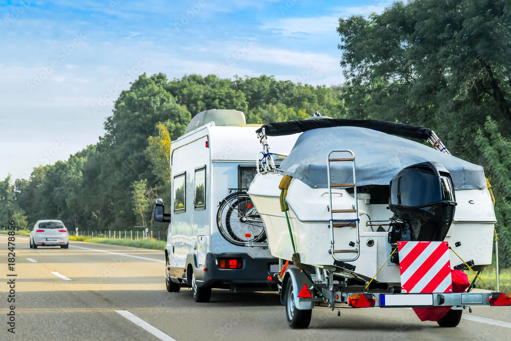 Caravan and trailer for motor boats on road in Switzerland Caravan and trailer for motor boats on road in Switzerland