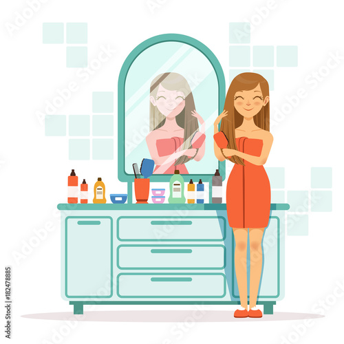 Happy woman combing hair a front of mirror