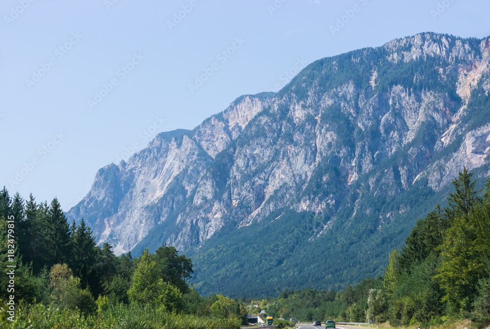 Road with cars and Alps mountains in Austria summer
