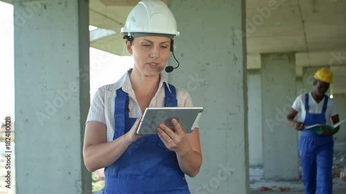Female and fro-american men are constructors considered building plan on a tablet