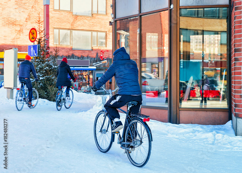 Person riding bicycle in snowy street of winter Rovaniemi