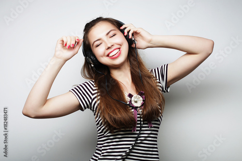 Woman with headphones listening music. Music girl dancing agains