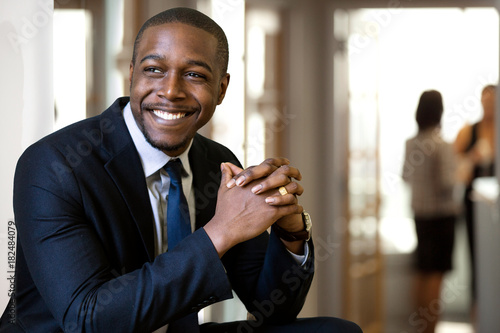 Enthusiastic chic handsome charismatic classy african american CEO in his office smiling confidently 