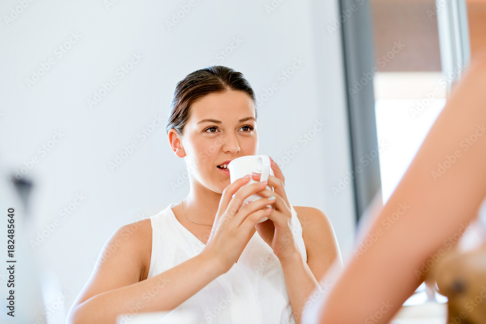 Young woman with her friend having tea at home Young woman with her friend having tea at home