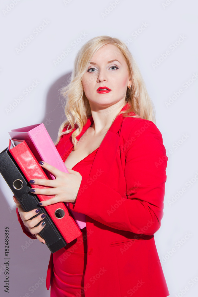 Portrait of a beautiful young blonde woman in a red business suit. The girl holds a folder for documents Portrait of a beautiful young blonde woman in a red business suit. The girl holds a folder for documents