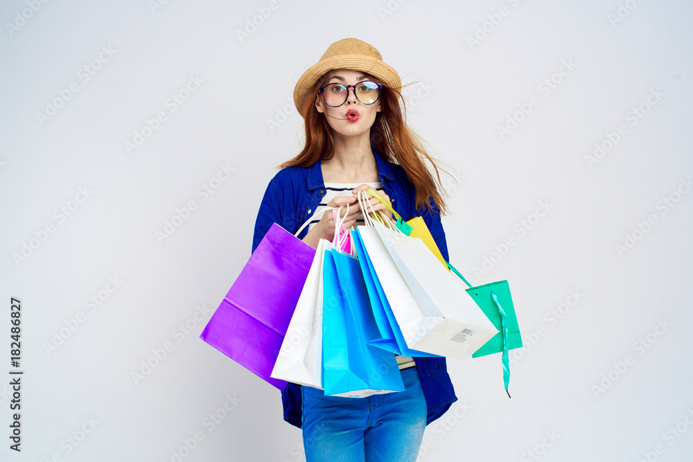 Shopaholic, woman holds many packages, shopping, emotions, gray background, joy