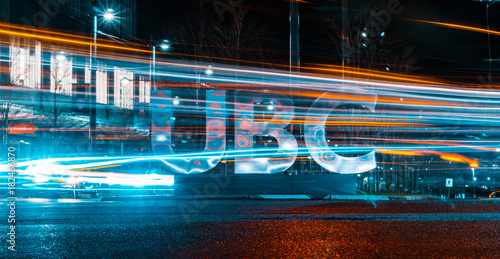 Long exposure of vehicles whizzing by UBC sign photo