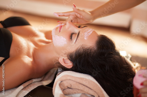 Spa. Beautiful woman relaxing during rejuvenating facial massage in a modern beauty center