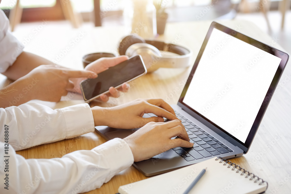 Fototapeta premium Two business people with laptop and smartphone meeting in modern office.