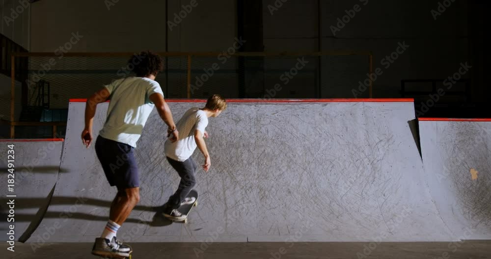 Male friends practicing skateboarding Male friends practicing skateboarding